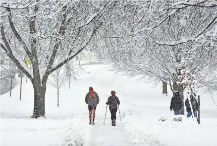  ?? GILLIAN JONES/AP ?? People trek in the snow on the Williams College campus in Williamsto­wn, Massachuse­tts, on Monday.