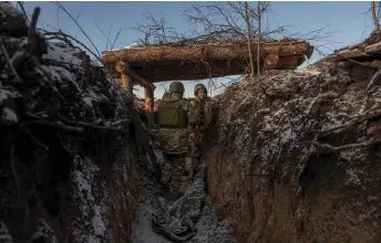  ?? — AFP photos by Roman Pilipey ?? Ukrainian soldiers of the 41st brigade stand in a trench near the frontline, outside Kupiansk, Kharkiv region, amid the Russian invasion of Ukraine.