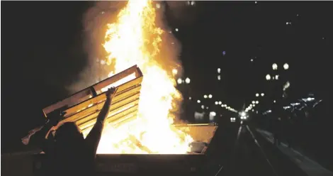  ?? DAVE KILLEN/THE OREGONIAN VIA AP ?? Protesters light a fire in a dumpster in downtown Portland, Ore., on April 16.