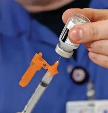  ?? STUART CAHILL / HERALD STAFF FILE ?? PROTECTING MORE PEOPLE: A Brewster paramedic/ nurse preps the Moderna vaccine as the Plymouth Fire Department gets its first doses of the coronaviru­s vaccine on Jan. 21 in Plymouth.