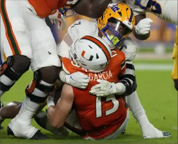  ?? Lynne Sladky/Associated Press ?? Pitt linebacker SirVocea Dennis wraps up Miami quarterbac­k Jake Garcia Satrurday night.