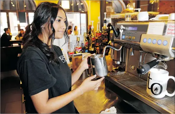  ?? GERRY KAHRMANN — PNG ?? Barista Jessica Raj froths milk at Trees Organic Coffee on Water Street in Vancouver’s Gastown on Tuesday.