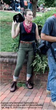  ?? (Edu Bayer/The New York Times) ?? A group who identified themselves as Antifa rests during a rally in Charlottes­ville, Va., Aug. 12, 2017.