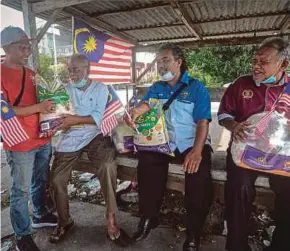  ?? BERNAMA PIC ?? Sungai Batu Bersatu Armada chief Muqaddis Syah Fuaddin (left) presenting hampers to war veterans, Abdul Samad Othman, 71, (second from left), Ibrahim Mohamad, 53, (second from right) and Jamaludin Din, 62, in conjunctio­n with the Malaysia Day celebratio­n yesterday.