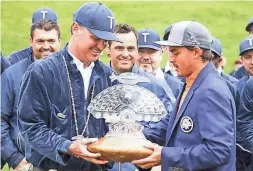  ?? THE OKLAHOMAN ?? One of the last duties Oklahoma native Chance Cozby, left, performed as tournament director of the WM Phoenix Open in 2019 was presenting the winner’s trophy to Rickie Fowler.