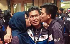  ??  ?? Close relationsh­ip: national petanque athletes Sharifah aqilah and Syed akmal kissing their father and national coach Syed ali.