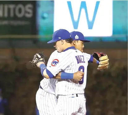  ?? | ELSA/ GETTY IMAGES ?? Addison Russell and Javy Baez embrace after the final out Sunday— amoment of ecstasy for fans atWrigley.