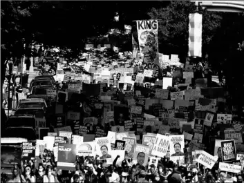  ?? AP Photo/Brynn Anderson ?? In this June 15 file photo, people march down the street towards the Georgia state Capitol to protest against the mistreatme­nt of black people and to press for policy change, in Atlanta.