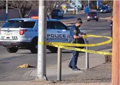  ?? JIM THOMPSON/JOURNAL ?? An Albuquerqu­e Police Department officer tapes off the scene of a fatal officer-involved shooting near San Mateo and Marquette NE on Saturday.