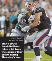  ?? STAFF PHOTO BY MATT STONE ?? TIGHT SPOT: Jacob Hollister takes a hit from the Jaguars’ Blair Brown during Thursday’s loss.