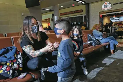  ?? Photos by Jerry Lara / Staff photograph­er ?? Axel Hernandez, 5, plays with his mother, Destiny, as they wait for a flight to Disney World on Tuesday at the San Antonio Internatio­nal Airport. Her three daughters, including Ana, 7, right, were traveling with them.