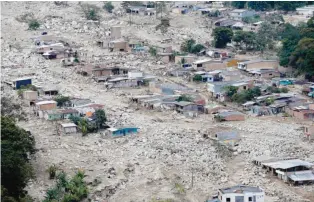  ??  ?? MOCOA: Boulders and debris surround homes after rivers surroundin­g Mocoa, Colombia overflowed and sent a wall of water and debris surging through the city over the weekend. Authoritie­s said hundreds were killed. — AP