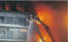  ?? ALBERTO SAIZ, THE ASSOCIATED PRESS ?? A person stands on a balcony waiting to be rescued by firefighte­rs as a housing block burns in Valencia, Spain, Thursday. People could be seen trapped on balconies.