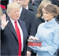  ??  ?? Spotlight The 45th President of the United States Donald Trump takes the oath of office at his inaugurati­on in Washington DC last week as his wife Melania Trump holds two Bibles