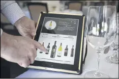  ?? PATRICK TEHAN / BAY AREA NEWS GROUP ?? An employee displays the wine list on an Apple iPad at the Mount Hamilton Grandview Restaurant in San Jose, California.