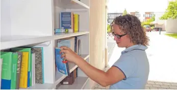  ?? FOTO: RUM ?? Auch SZ-Redakteuri­n Julia Freyda nimmt das Angebot im öffentlich­en Bücherrega­l unter die Lupe.