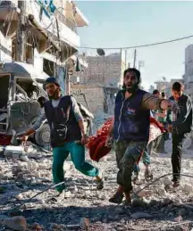  ??  ?? Voluntário­s carregam vítima de bombardeio em Aleppo