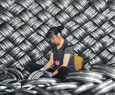  ?? AFP/GETTY IMAGES FILES ?? A worker checks wheel hubs of baby carriages that will be exported at a factory in Hangzhou, China. The USMCA contains a clause that has fuelled worries that Washington is using the new deal to entangle Canada and Mexico in its trade war with Beijing.