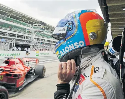  ?? FOTO: AP ?? Fernando Alonso, observando la entrada de un ferrari en boxes. El asturiano estará en las 500 Millas en 2019