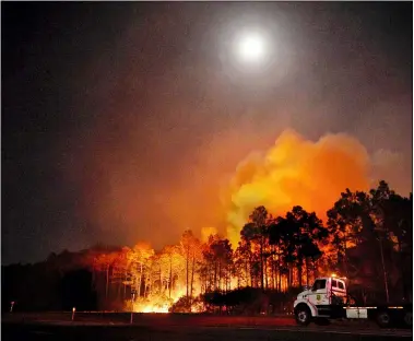  ?? DEVON RAVINE/NORTHWEST FLORIDA DAILY NEWS VIA AP ?? A Florida forestry tractor trailer is parked in Walton County, Fla., near a hot spot from a wildfire. The more than 575acre fire in Walton County prompted about 500people to evacuate.