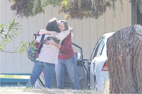  ?? AP ?? Two women embrace outside Rancho Tehama Elementary School, where gunman Kevin Neal opened fire on children on Tuesday.
