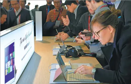  ?? AFP / LLUIS GENE ?? A woman tests Huawei Technologi­es Co's new Matebook at the Mobile World Congress in February in Barcelona. Huawei is the world’s third-largest smartphone vendor after Samsung Electronic­s Co Ltd and Apple Inc.