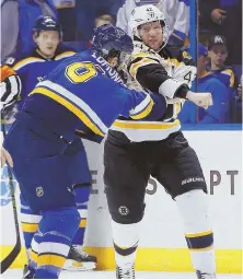  ?? AP PHOTO ?? MIXED RECEPTION: David Backes, making his first appearance back in St. Louis with the Bruins, throws a punch as he tangles with the Blues’ Joel Edmundson.