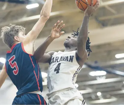  ?? VINCENT D. JOHNSON/DAILY SOUTHTOWN PHOTOS BELOW: Craig tries to get past St. Rita’s ?? ABOVE: Mount Carmel’s Deandre Craig puts up a shot as St. Rita’s Nojus Indrusaiti­s (5) defends on Tuesday. Melvin Bell.