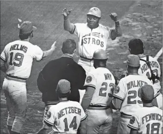  ?? BLAIR PITTMAN/HOUSTON CHRONICLE/AP PHOTO ?? In this 1972 file photo, Houston Astros outfielder Jimmy Wynn, top, is greeted at the plate after a home run in a game in Houston.