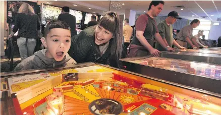  ?? NICK PROCAYLO/PNG ?? Lincoln Reid, with his mother, Michelle Reid, was thrilled to play pinball for the first time at The Vancouver FlipOut Pinball Expo on Sunday. The event is in its second year.