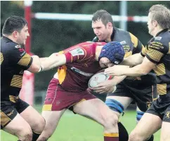  ??  ?? Caernarfon’s Dafydd Lloyd takes on a trio of Bethesda opponents during the sides’ clash last Saturday.