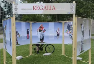  ?? PHOTOS BY JOHN RENNISON, THE HAMILTON SPECTATOR ?? A man on a bike stops to read a descriptio­n of regalia on a display on the McMaster University campus.