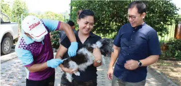  ??  ?? A dog owner has her dog vaccinated during the programme.