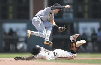  ?? Photos by Lachlan Cunningham / Getty Images ?? Thairo Estrada of the Giants stole second base as Kevin Newman of the Pirates was unable to reel in the throw from the catcher, allowing Steven Duggar to score in the bottom of the sixth.