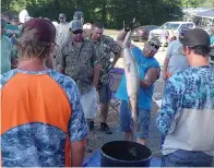  ??  ?? ■ Judd Hickerson is getting ready to weigh one of his biggest catches in the Deadhead Archery fishing tournament held Saturday in Queen City.