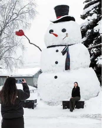  ?? — ap ?? a file photo of a woman taking a photo of her sister-in-law in front of snowzilla in anchorage, alaska.