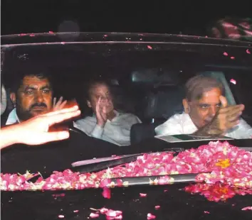  ?? AFP ?? Former PM Nawaz Sharif (middle) waves to supporters as he arrives at the Noor Khan Airbase, from where he was expected to fly to Lahore yesterday.