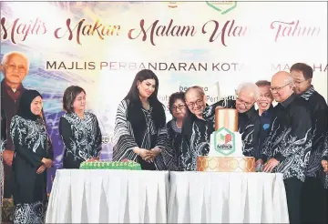  ?? — Photo by Mohd Rais Sanusi ?? Taib (fourth right) cuts the anniversar­y cake, witnessed by Uggah (fifth right), Minos (second right), Dr Sim (third right), Abdul Karim (right), Nancy (left) and Ragad third left.