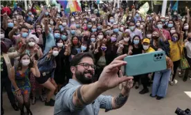  ?? Photograph: Esteban Félix/ AP ?? Gabriel Boric takes a selfie with members of his electoral campaign and supporters after presenting his government program in Santiago on 1 November.