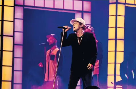  ??  ?? Bruno Mars and his seven-piece band performed on what looked like a giant TV