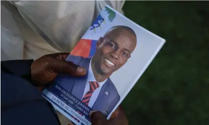  ?? Photograph: Ricardo Arduengo/Reuters ?? A person holds a photo of Jovenel Moïse during his funeral in Cap-Haïtien, Haiti, in July 2021.