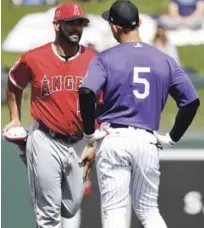  ??  ?? El dominicano Albert Pujols conversa con el venezolano Carlos González previo al aprtido que celebraron ayer Anaheim versus los Rockies.