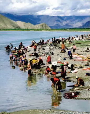  ??  ?? Каждый год в июле по тибетскому календарю (сентябрь по григорианс­кому) в Тибете наступает фестиваль купания: в реках купаются местные жители. Этот обычай в древности породил тибетские целебные ванны. На снимке: тибетцы празднуют фестиваль купания на берегу реки Лхаса (фото CFB)