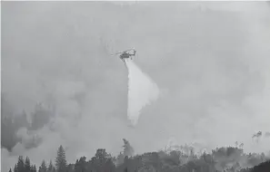  ??  ?? A helicopter drops water on the Grizzly Creek Fire on Glenwood Canyon on Monday near Glenwood Springs, Colo. HELEN H. RICHARDSON/ AP