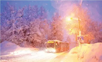  ??  ?? A bus drives on the road during heavy snowfall in Reitdorf, Austria. Communitie­s have been cut off and travel disrupted as a fresh wave of wintry weather hit southern Germany and Austria.— Reuters photo