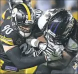  ??  ?? Steelers linebacker T.J. Watt, left, wraps up Ravens running back Alex Collins.