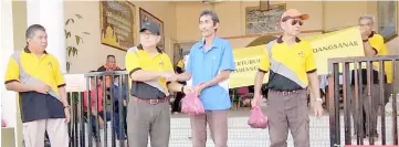  ??  ?? Mohamad (second left) hands over ‘korban’ meat to a representa­tive of the organisati­on at Surau Darul Insyirah of IPG Sarawak.