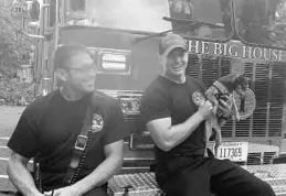  ?? CAITLIN DOORNBOS/STAFF ?? While sitting on a truck, Orlando Fire Department engineer Dean Dukat, left, and firefighte­r Daniel Wade hold Zoe, a chihuahua that Wade took for a walk.