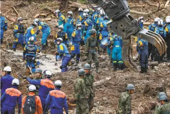  ?? Takuto Kaneko / Kyodo News ?? Emergency personnel search for possible survivors at the site of a landslide in the town of Tsunagi in southern Japan. Rain threatened wider areas of the surroundin­g island of Kyushu.