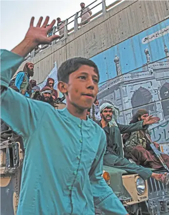  ?? Andrew Quilty / Agence Vu ?? An Afghan boy in front of Taliban fighters in Kabul this week.